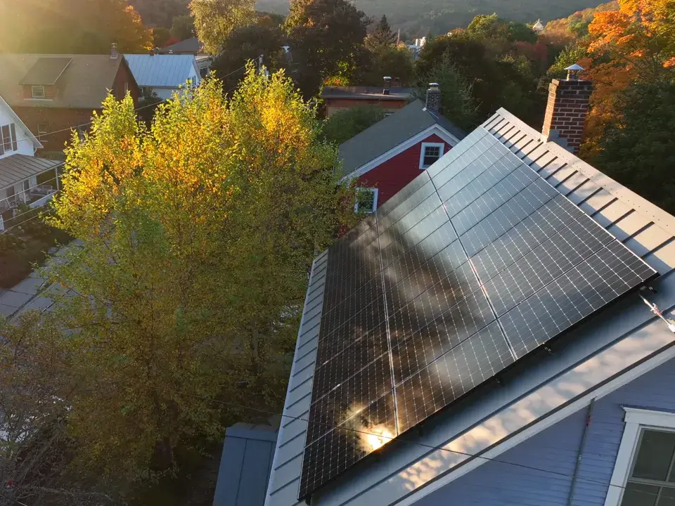 Photovoltaikanlage auf dem Dach eines Einfamilienhauses im Herbstlicht