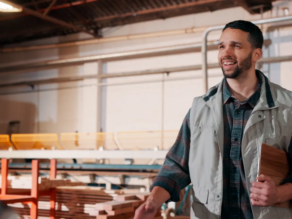 A sales engineer shaking hands with a customer on a workshop floor