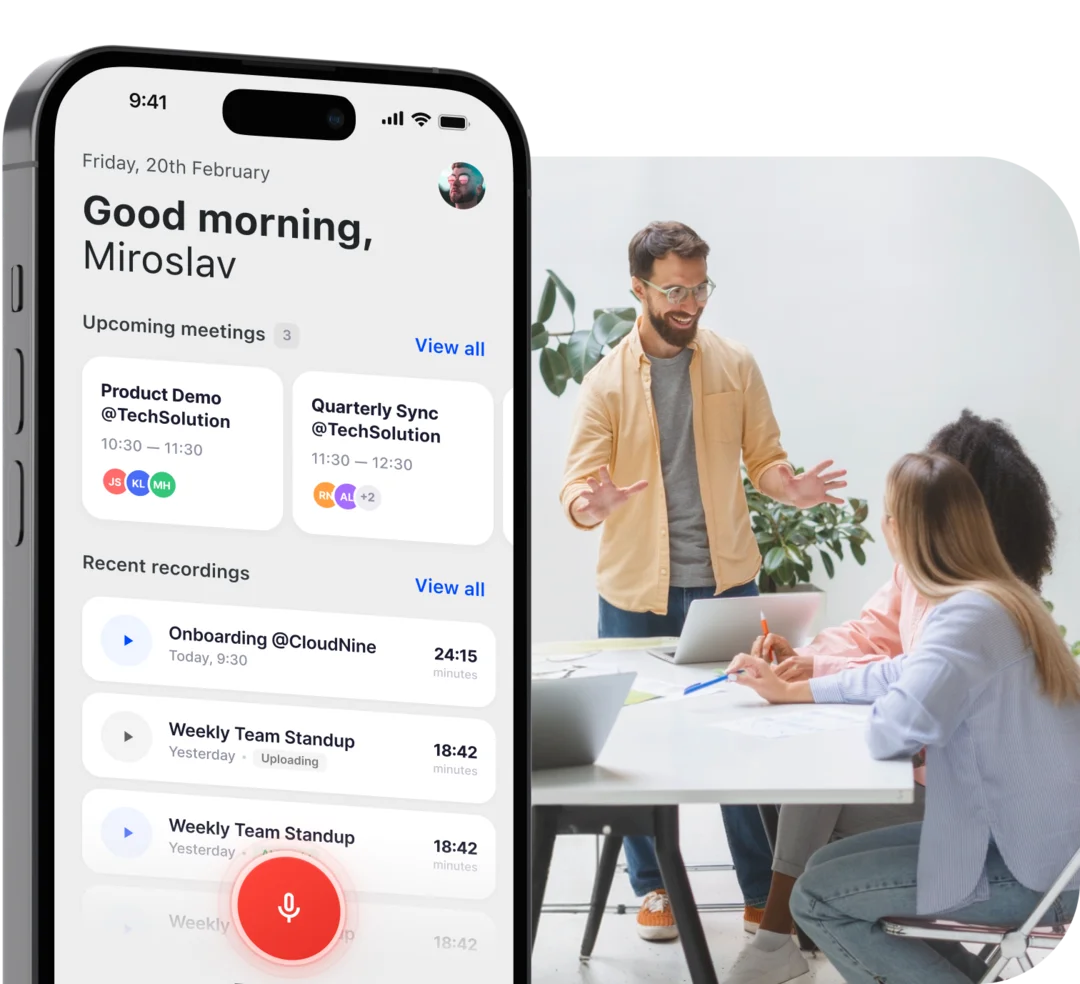Die Demodesk App auf einem Telefon neben einem Teammeeting am Tisch